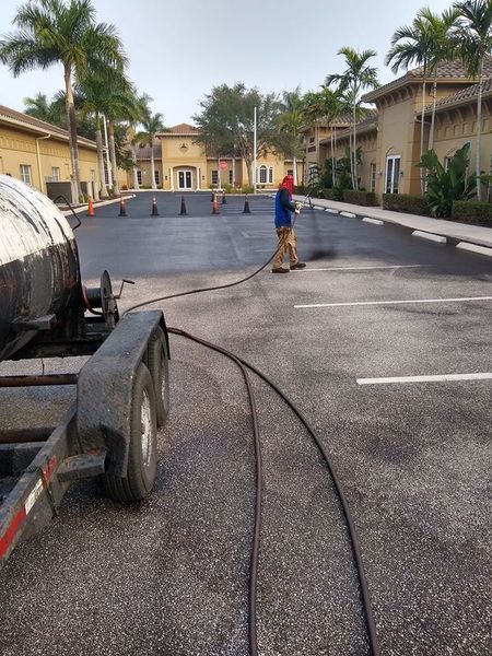 A man is standing in a parking lot next to a trailer.