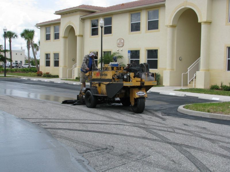 A man is working on a road in front of a building