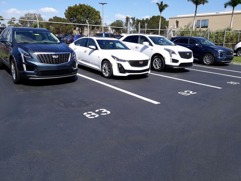 A row of cars are parked in a parking lot.