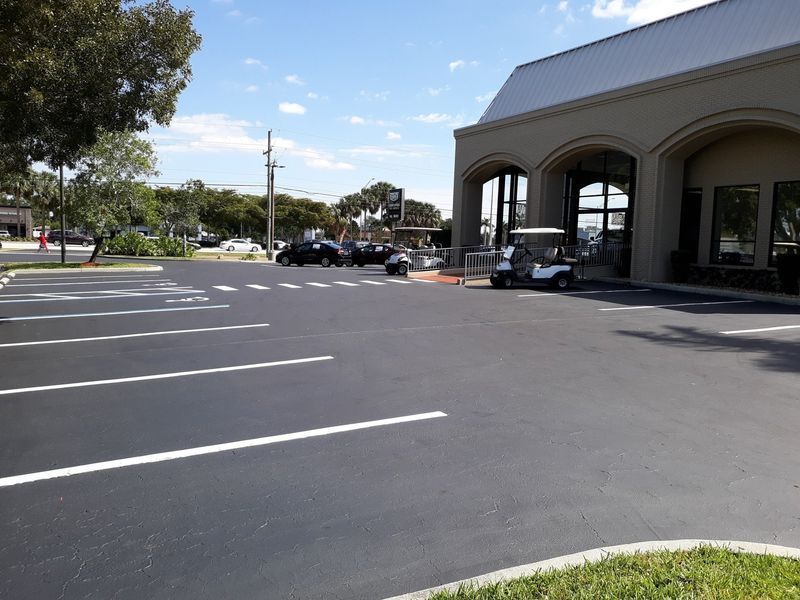 A golf cart is parked in a parking lot in front of a building