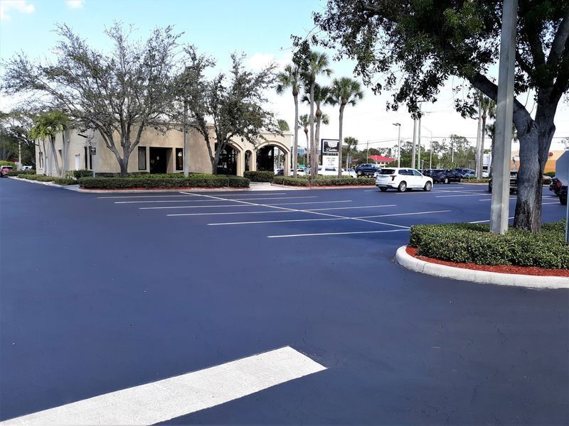 A parking lot with cars parked in front of a building.