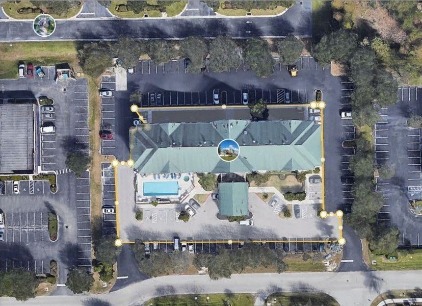 An aerial view of a large building with a pool