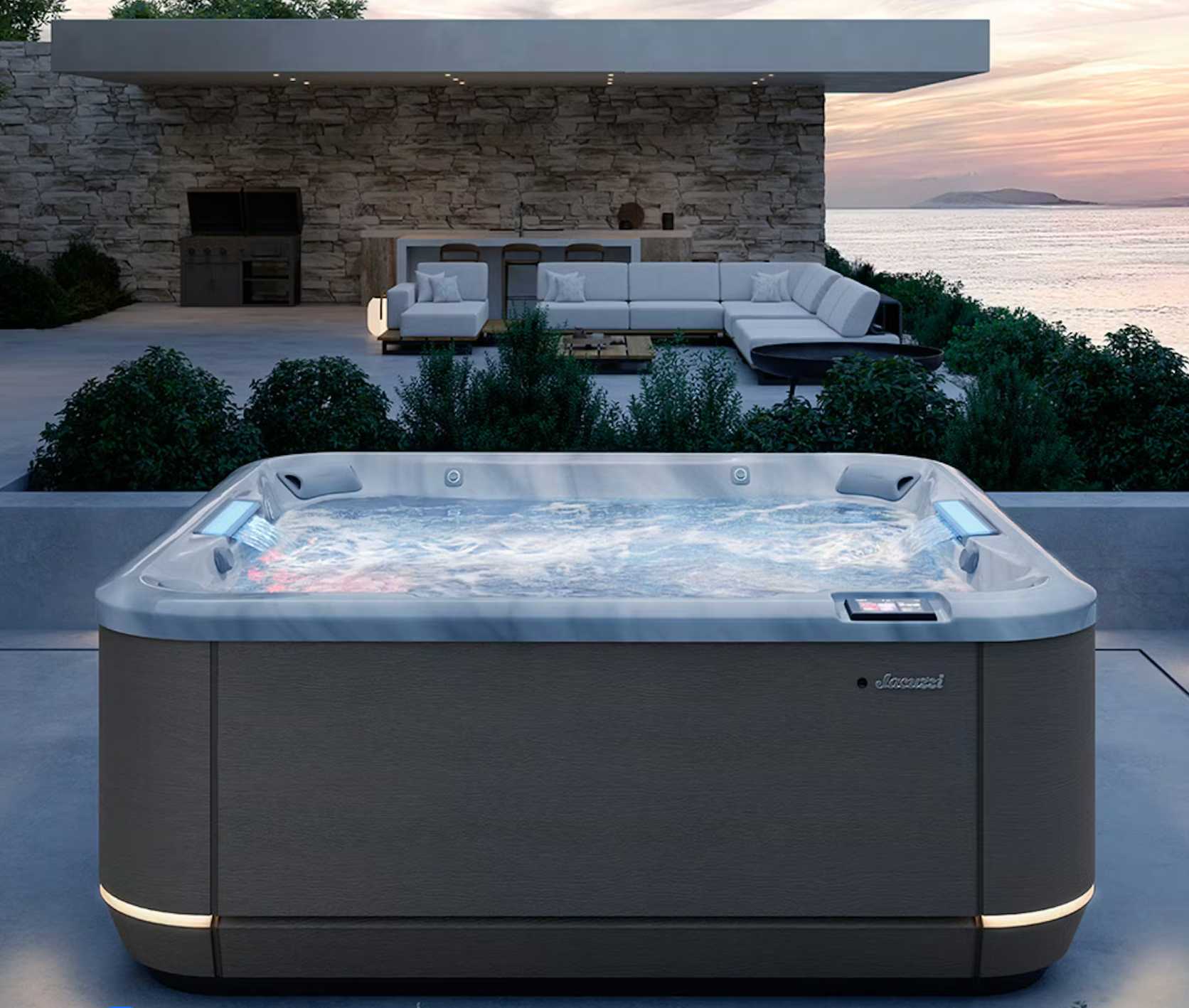 Jacuzzi sur une terrasse avec vue sur l'océan au coucher du soleil. Baignoire gris foncé