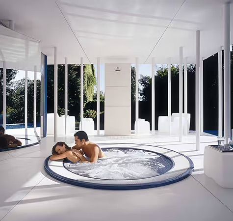 Une vue aérienne d'un complexe avec deux jacuzzis près de l'océan.