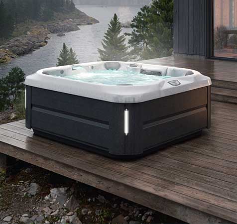 Un bain à remous est installé sur une terrasse en bois à côté d'une rivière.