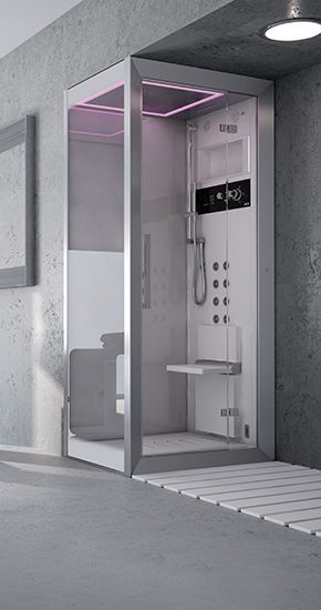 Une salle de bain avec une cabine de douche et un miroir au mur.