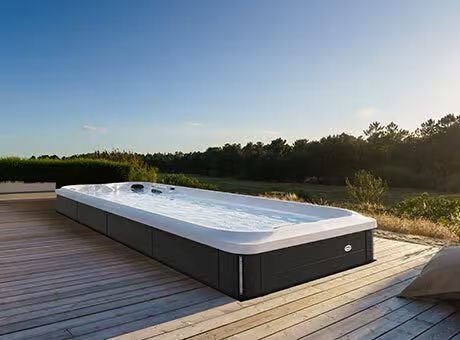 Une grande piscine est située au sommet d'une terrasse en bois.