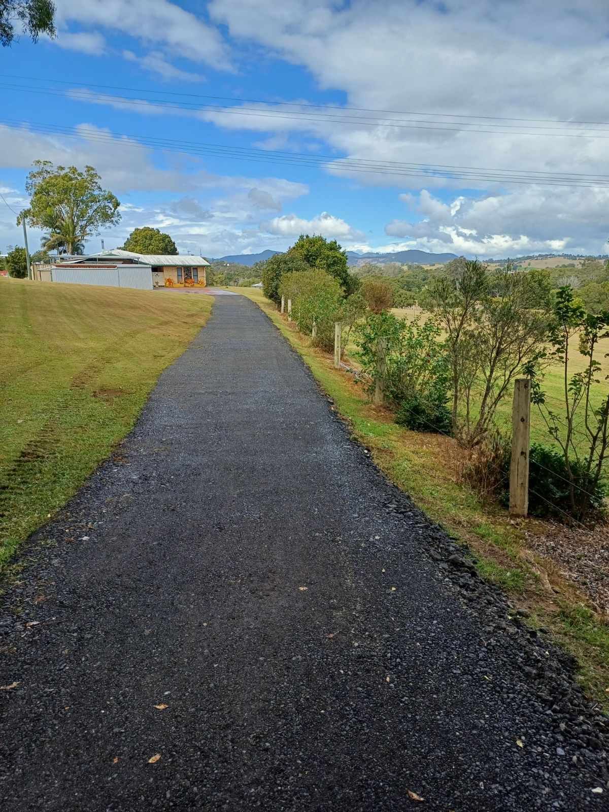 An Asphalt Driveway Leads to a Yellow House — CK's Milling & Earthworks in Bells Bridge, QLD