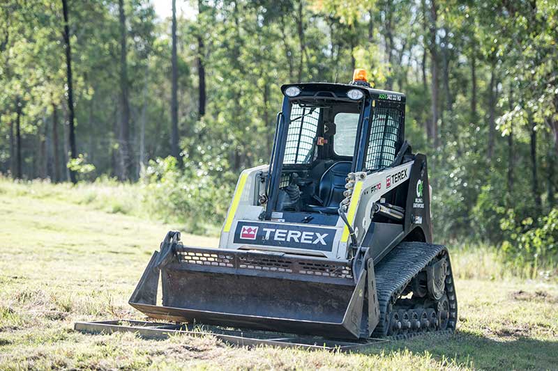 A Small Bulldozer Is Driving Through a Grassy Field — CK's Milling & Earthworks in Bells Bridge, QLD