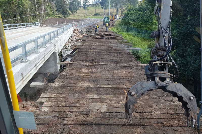A Bridge Is Being Demolished by A Crane — CK's Milling & Earthworks in Bells Bridge, QLD