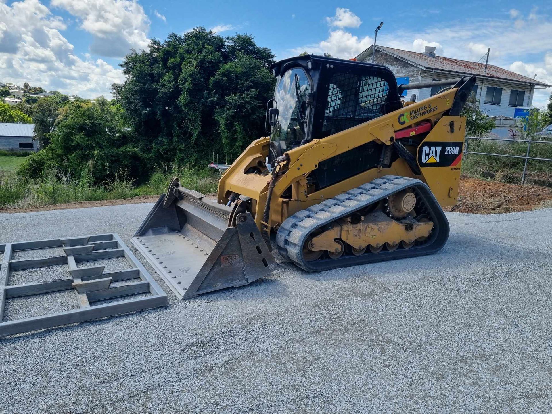 A Yellow Digger Is Working On Some Gravel — CK's Milling & Earthworks in Bells Bridge, QLD