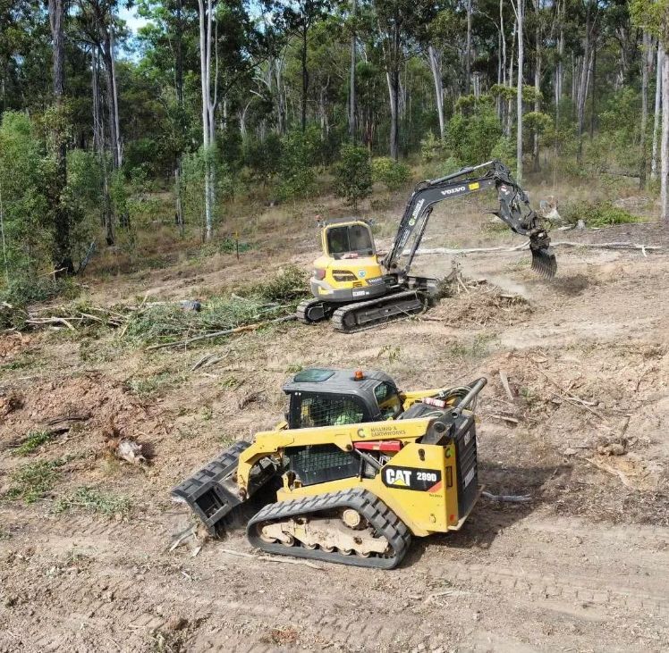 Two Bulldozers Are Working in A Dirt Field with Trees in The Background — CK's Milling & Earthworks in Bells Bridge, QLD