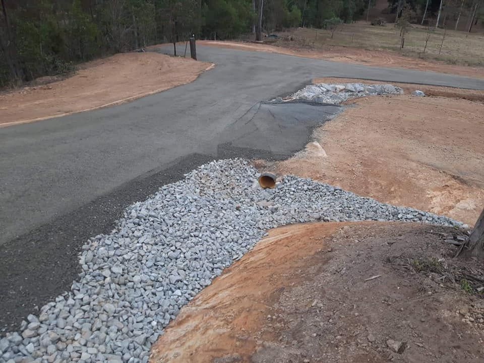 A Concrete Driveway Has Been Laid On Red Dirt — CK's Milling & Earthworks in Gympie, QLD