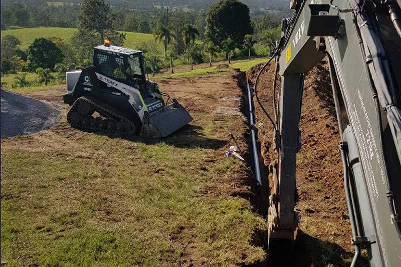 A Bulldozer Is Digging a Hole in The Ground in A Field — CK's Milling & Earthworks in Gympie, QLD