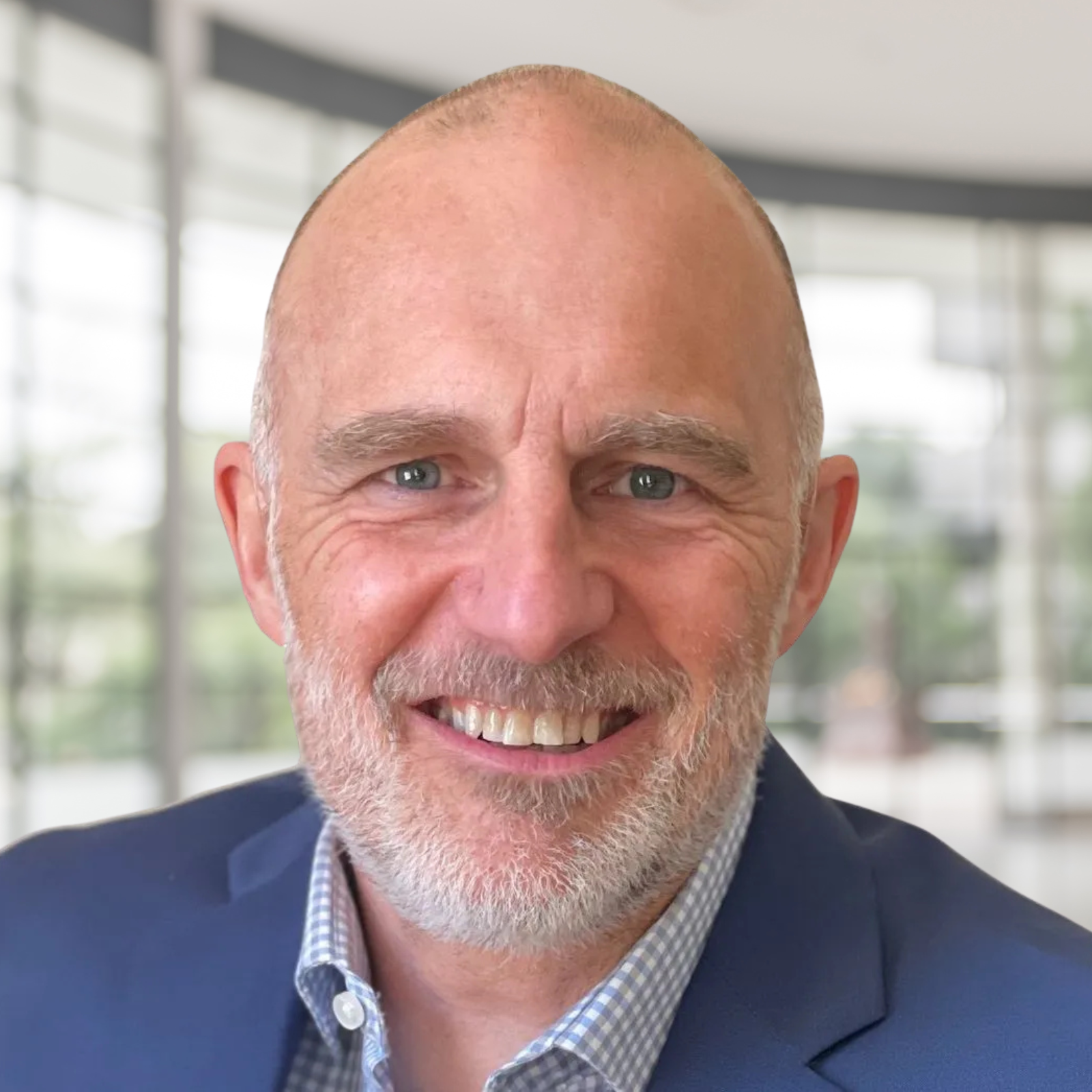 A bald man with a beard is wearing a blue suit and smiling