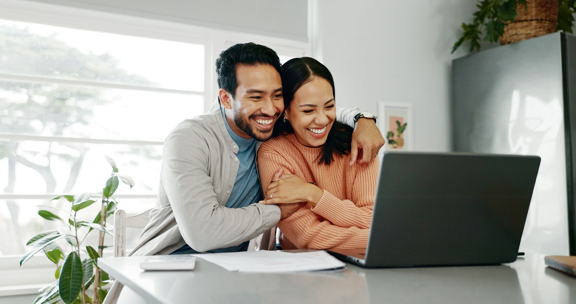 Happy Couple Looking at Their Insurance on Laptop