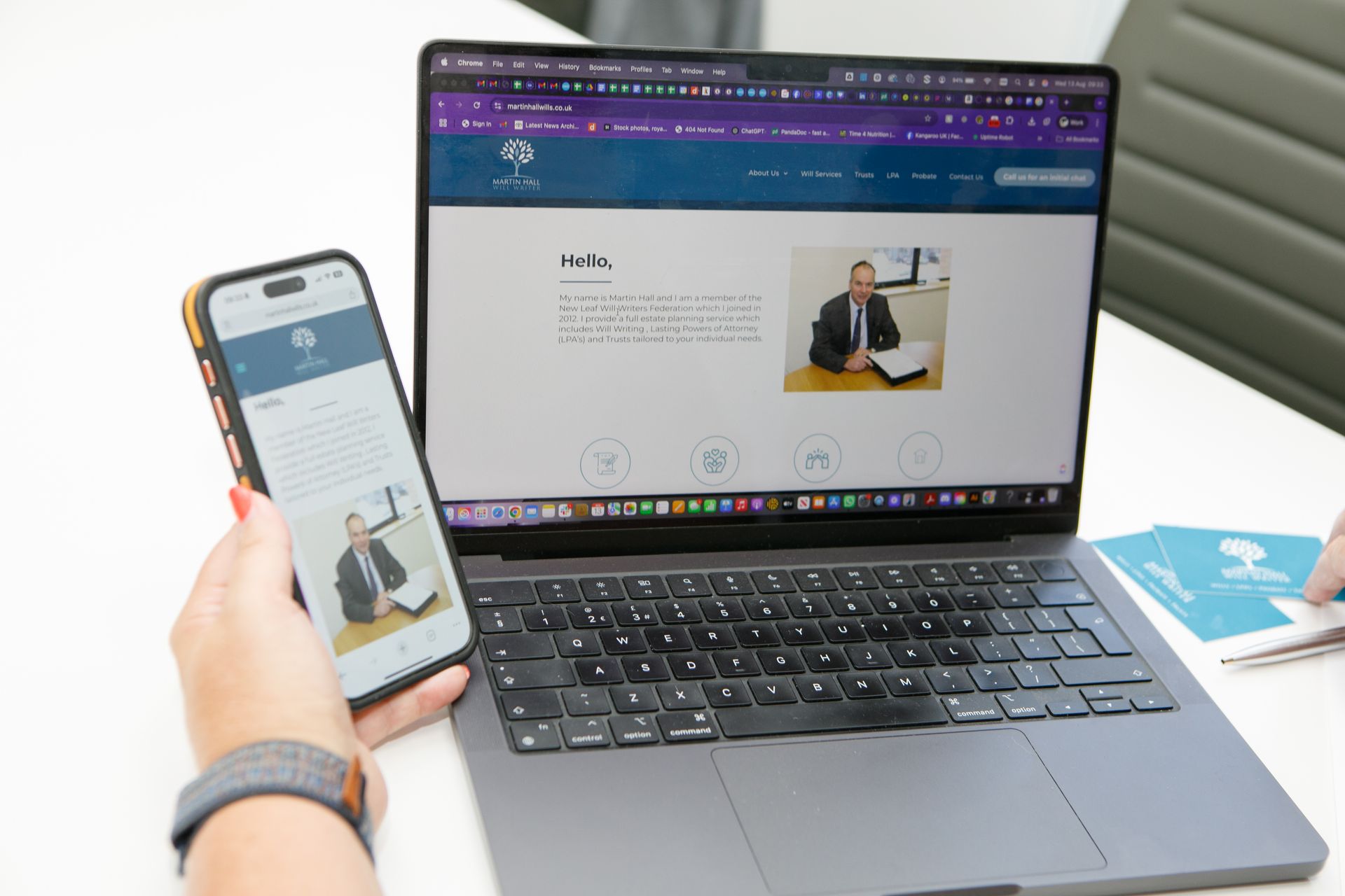 Person using a laptop and smartphone, both displaying a website with a man's photo.