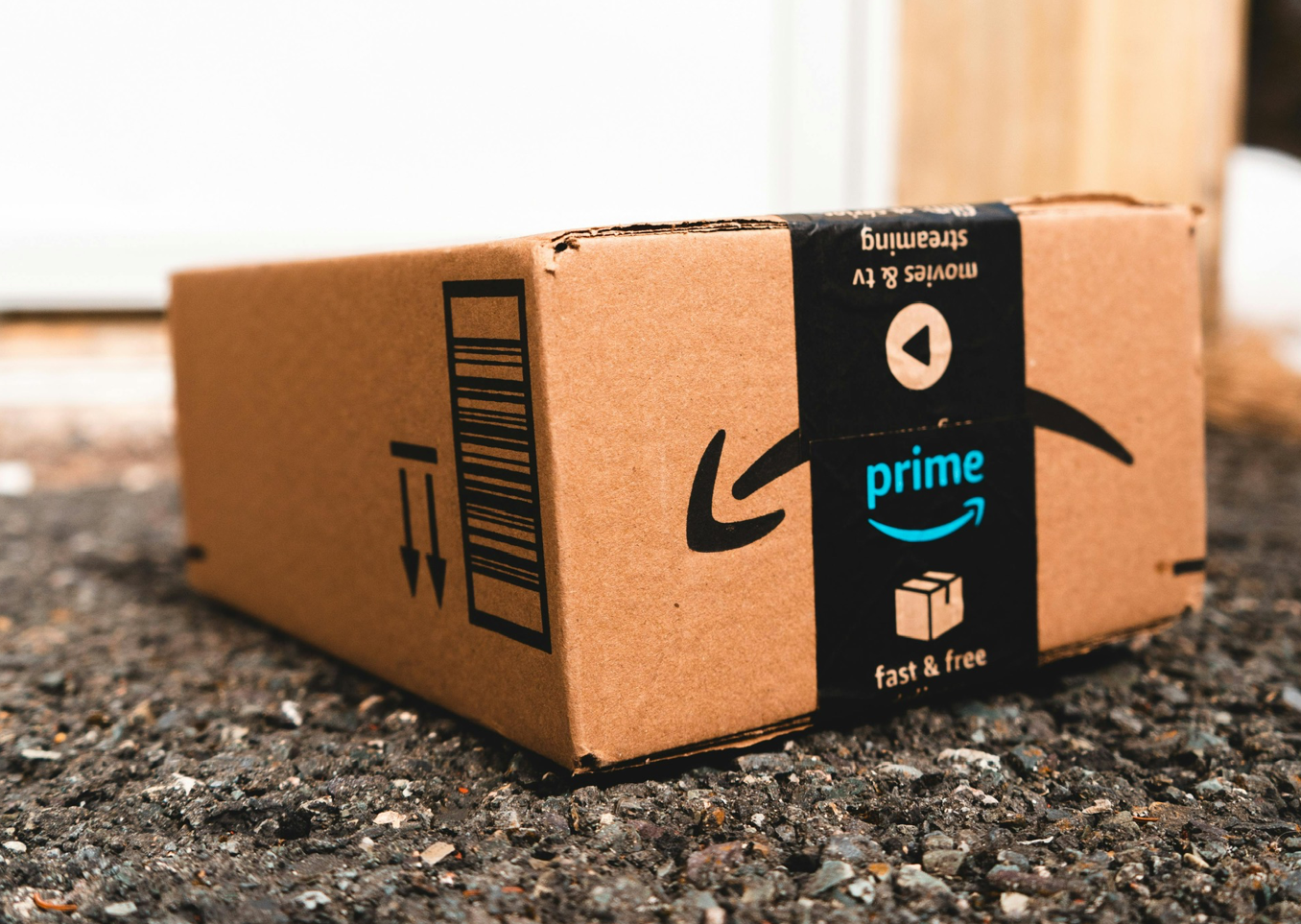 Amazon Prime box on a textured ground, black tape with logo.