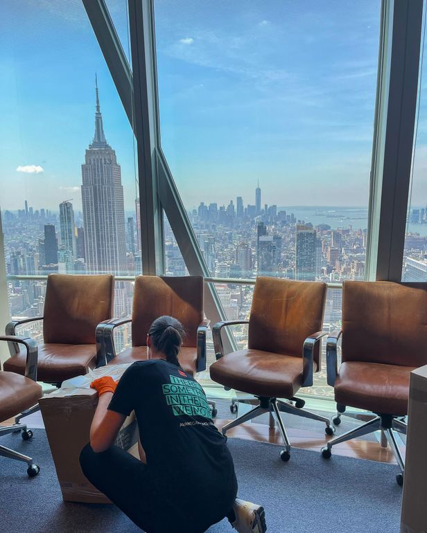 Photo of our mover/packer taping packed box in a tall building with a nice Manhattan view