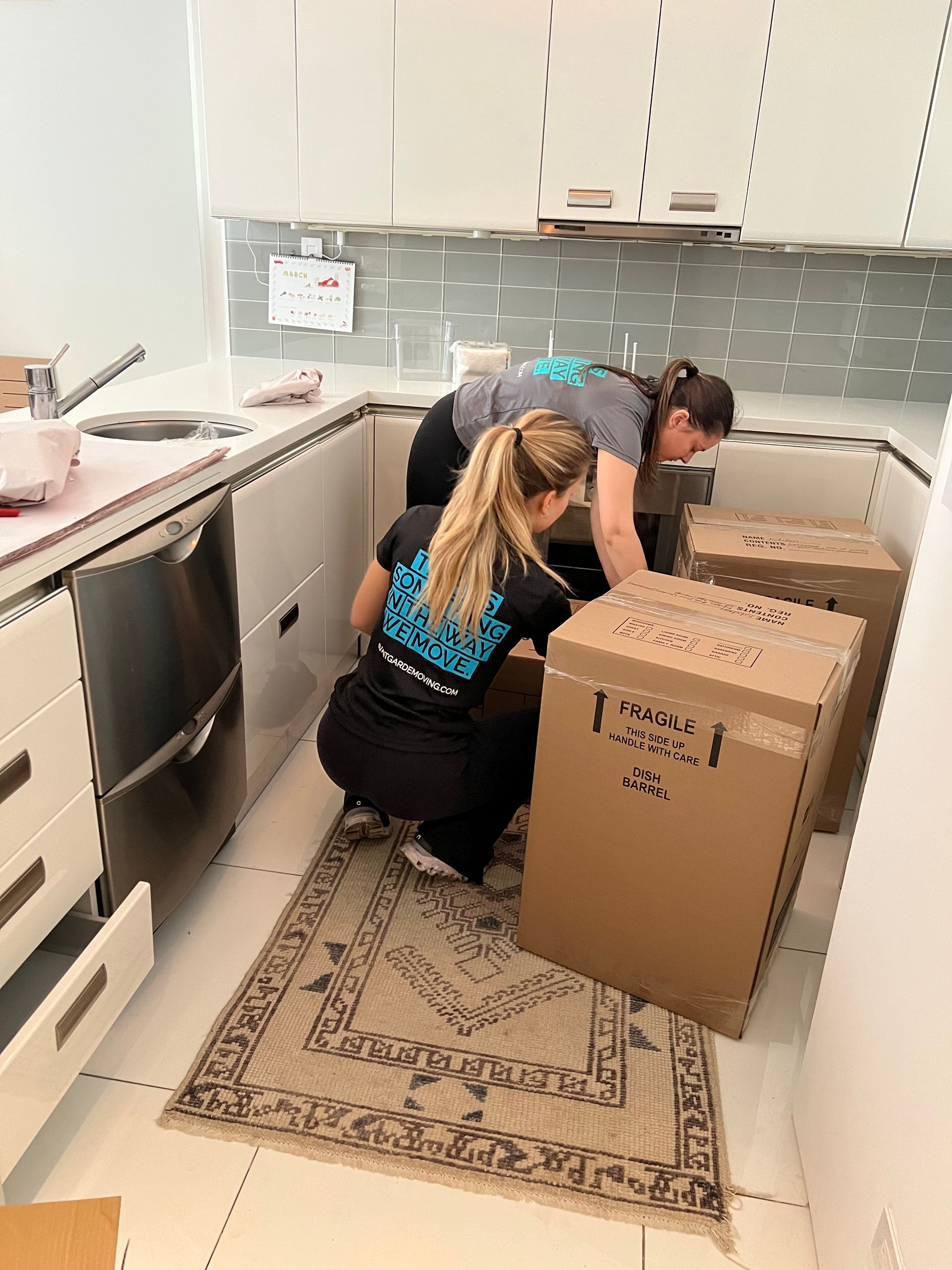 packers / movers packing up kitchen in a moving box 