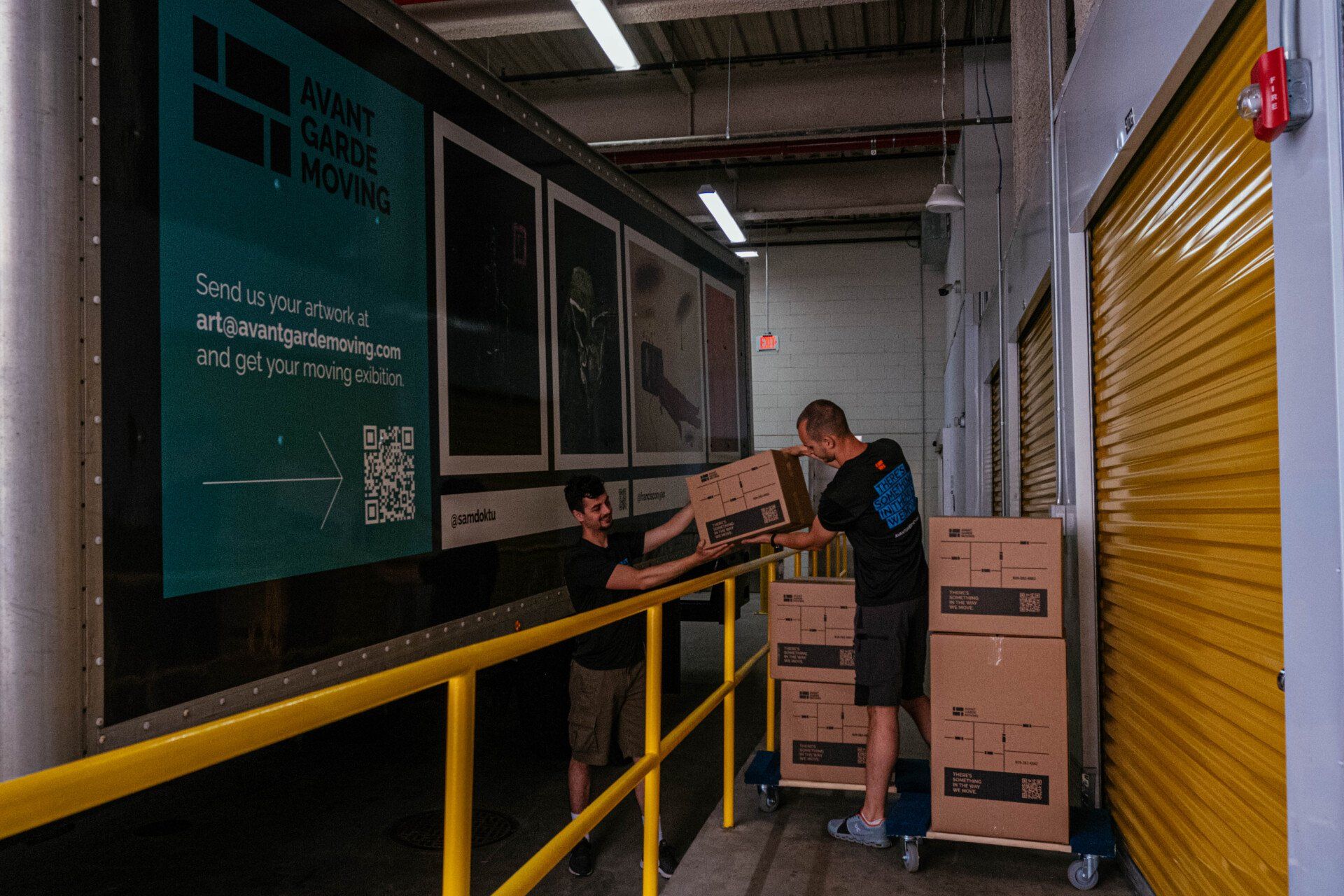 Two men are loading boxes onto a truck in a warehouse.