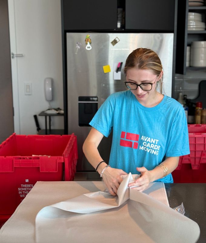 Photo of our packer packing up dishes in the kitchen 