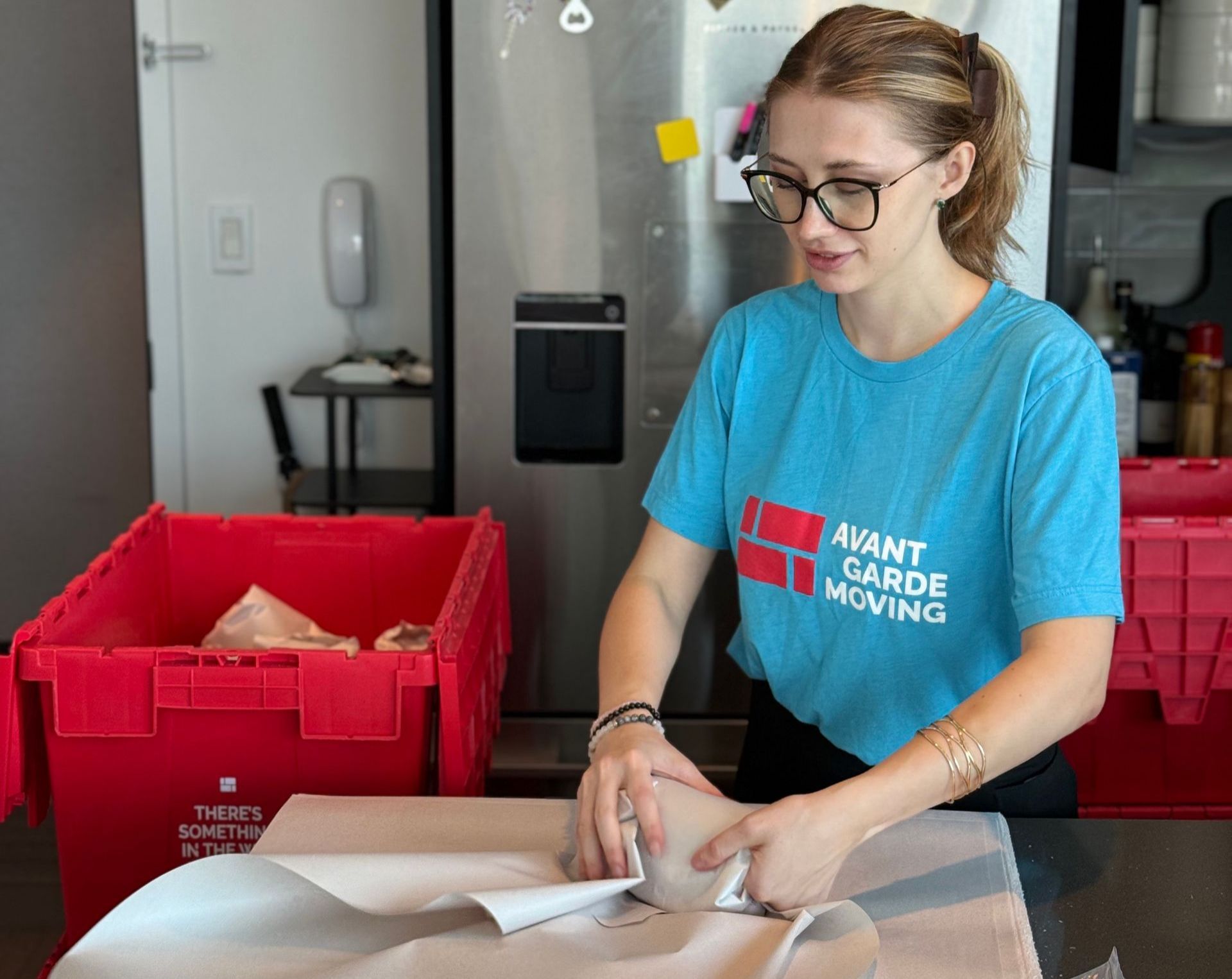 Photo of Avant-Garde packer carefully packing dishes and pantry in the kitchen 