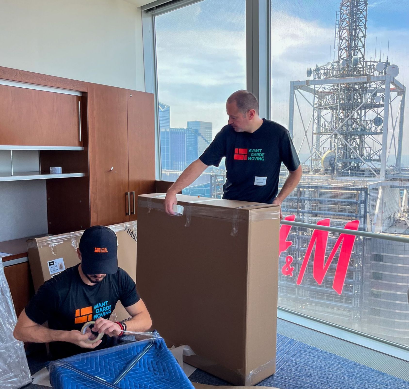 photo of avant-garde white glove movers wrapping and protecting furniture in the apt  