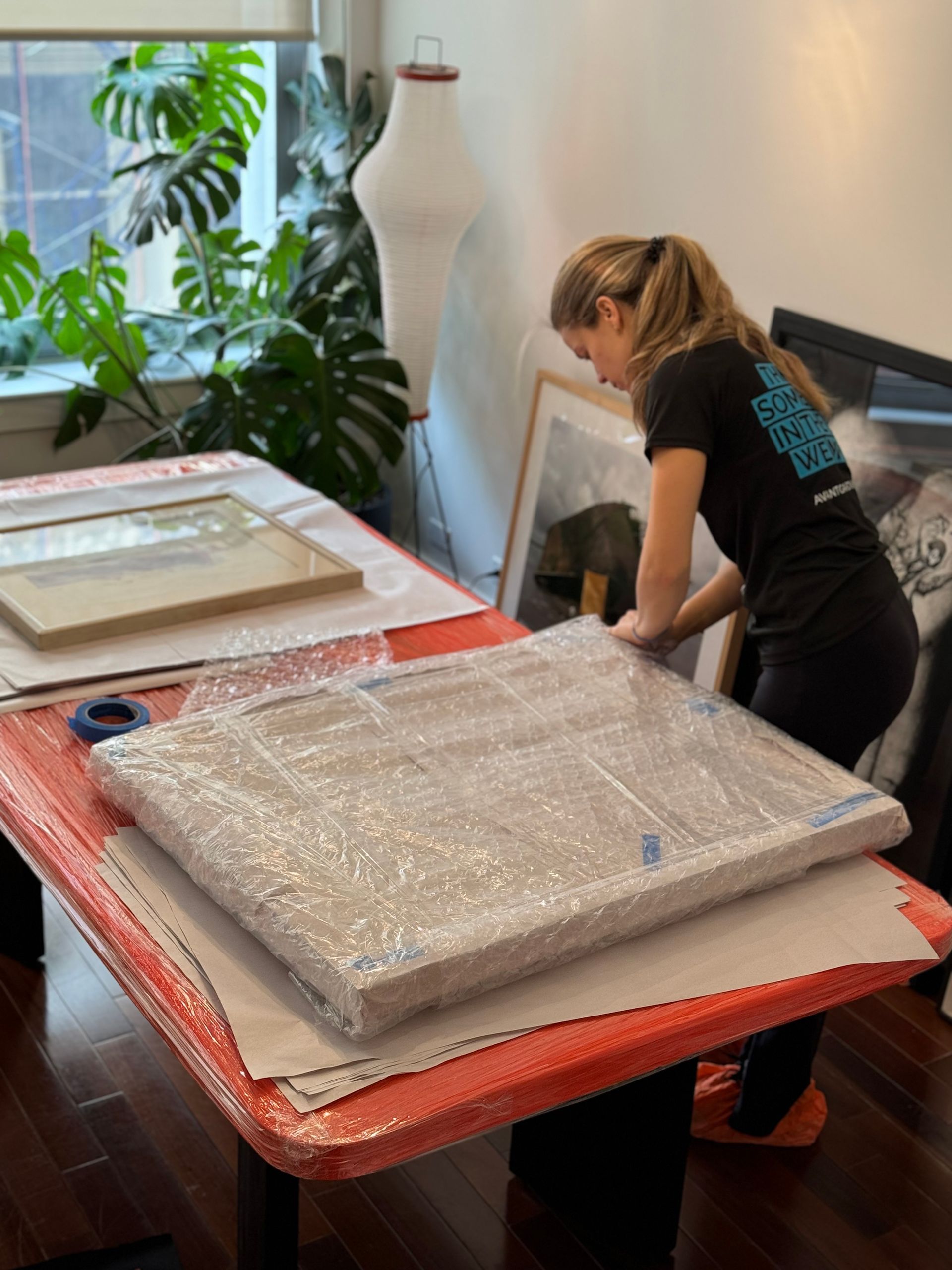 Photo of Avant-Garde  Fine Art packer packing up paintings with paper and bubble wrap