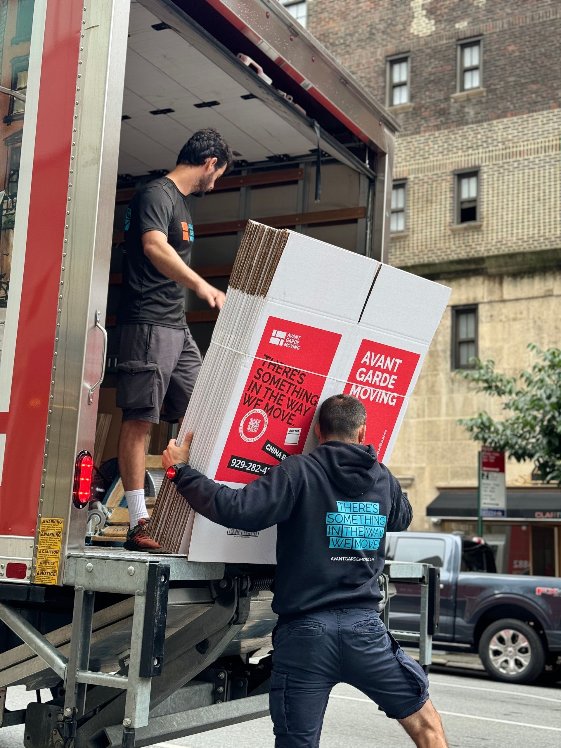 photo of our movers unloading the boxes and packing/moving material form the truck 