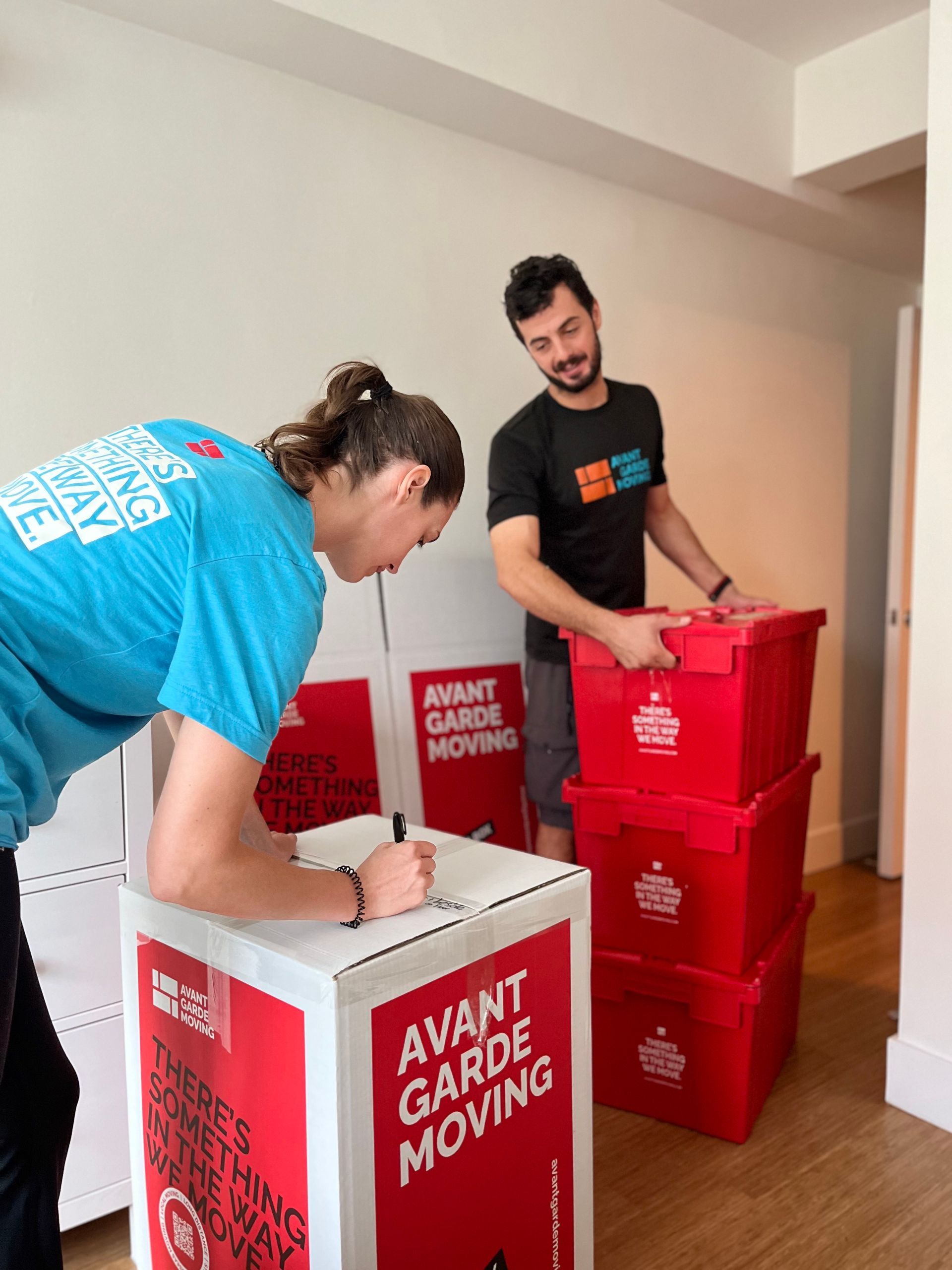 Photo of avant-garde moving packers labeling packed boxes