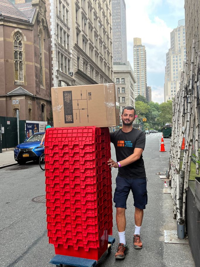 a mover taking used plastic bins back to the truck after completed move 