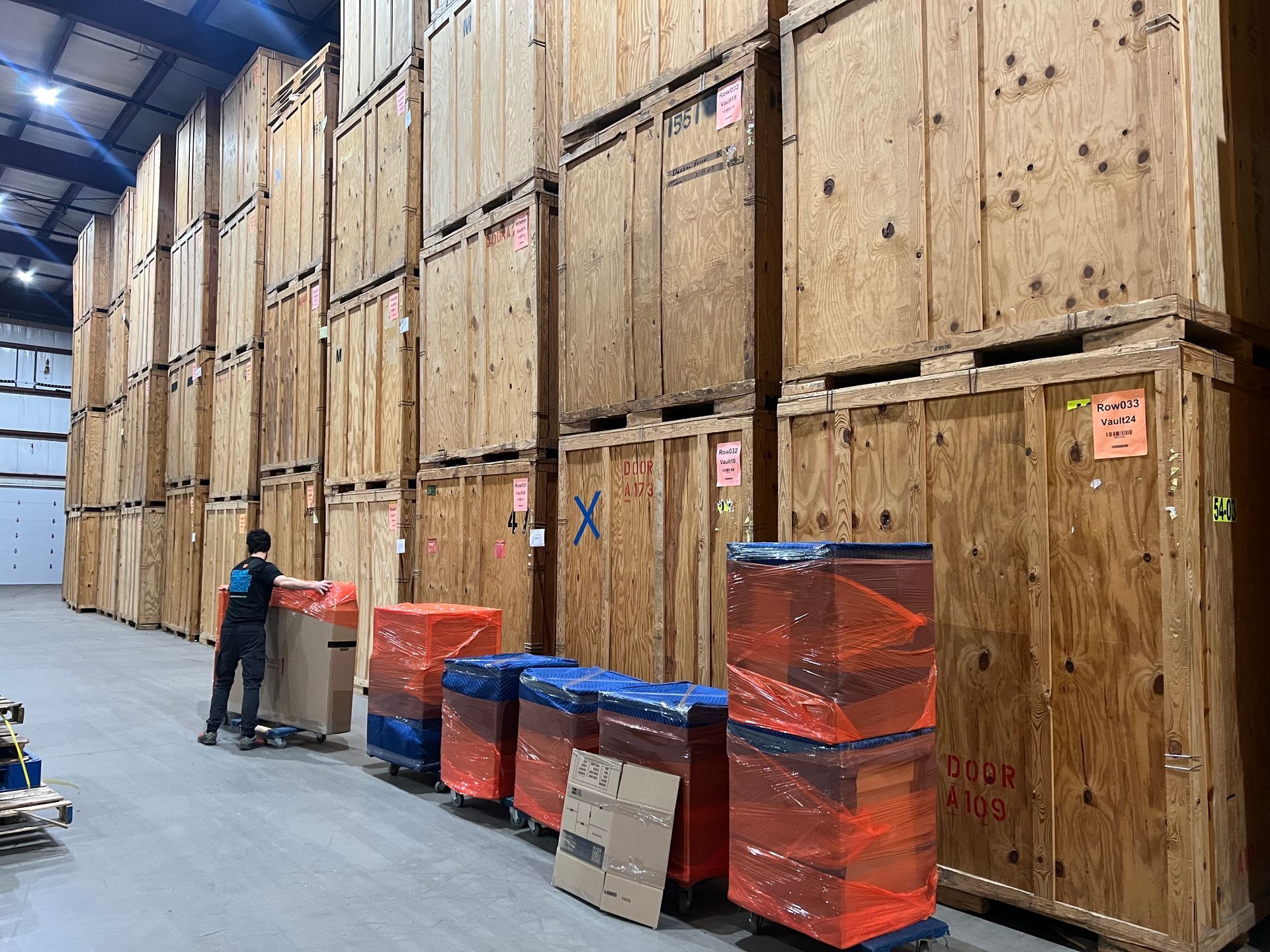 two men helping each other move boxes in a storage