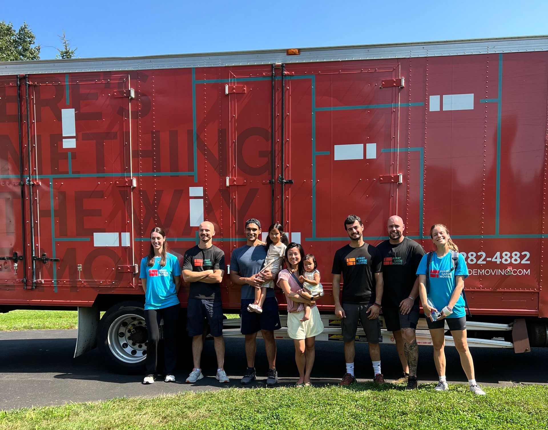 Photo of Avant-Grade movers and packers with the customers in front of their house, after a successful move was done 