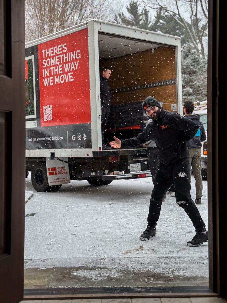 Avant-Garde Moving team unloading a truck in snowy weather, showcasing their dedication to seamless moves in any condition.