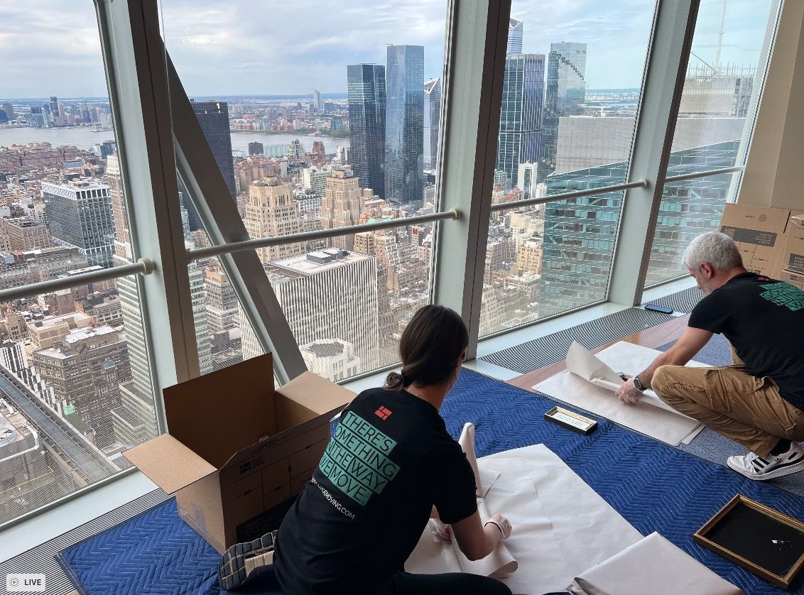 Photo of avant-garde moves and packers packing up office space in Manhattan, with the city view behind