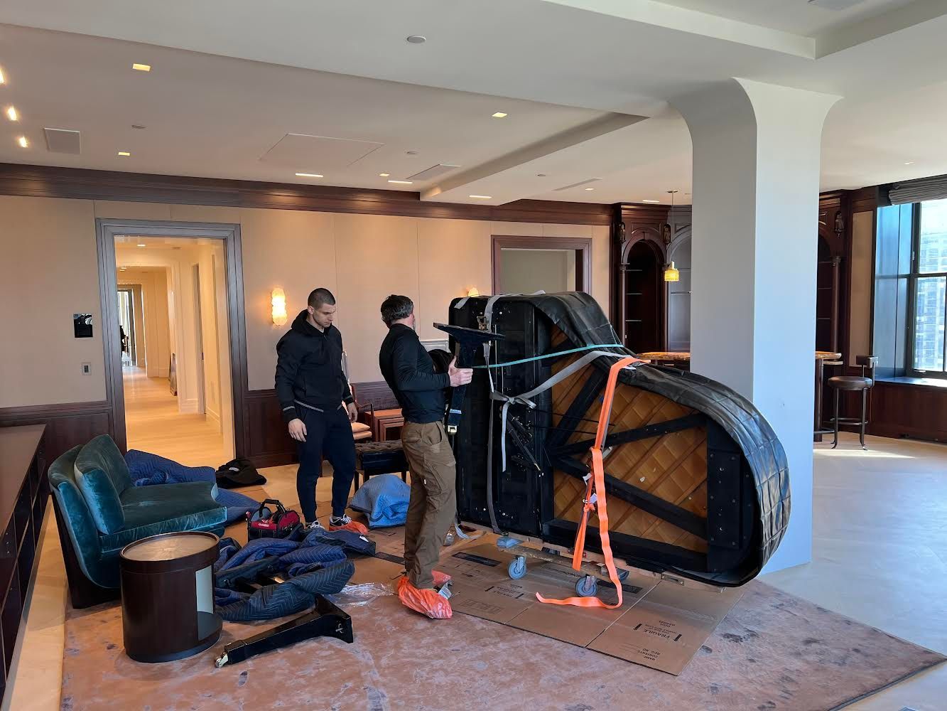 Piano movers wrapping and protecting piano for moving 