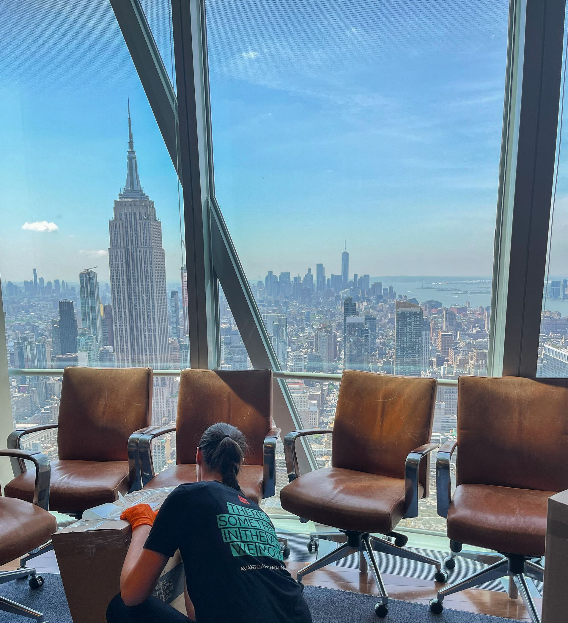 Avant-garde mover packing boxes in Manhattan office overlooking Empire State