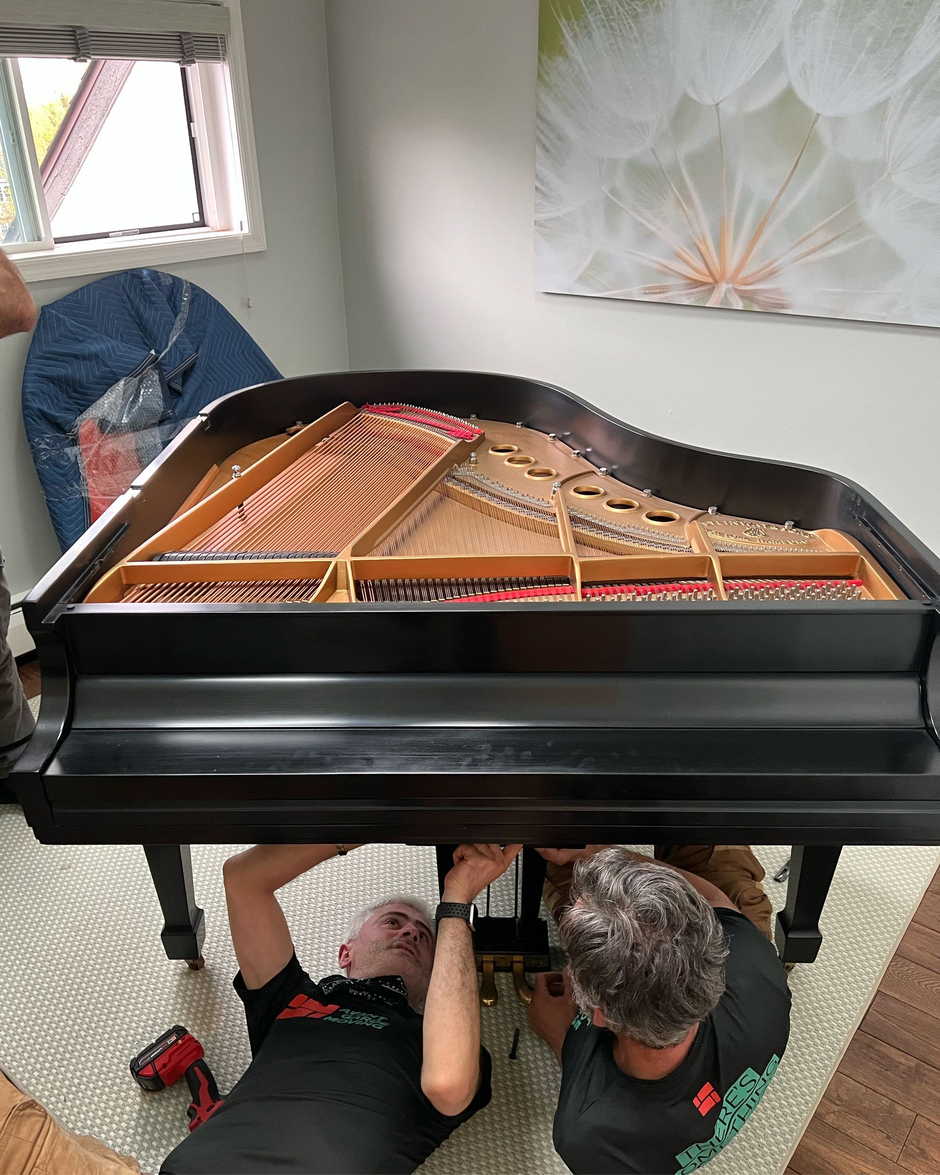 Photo of our professional piano movers making sure baby grand piano is tuned perfectly upon delivery 