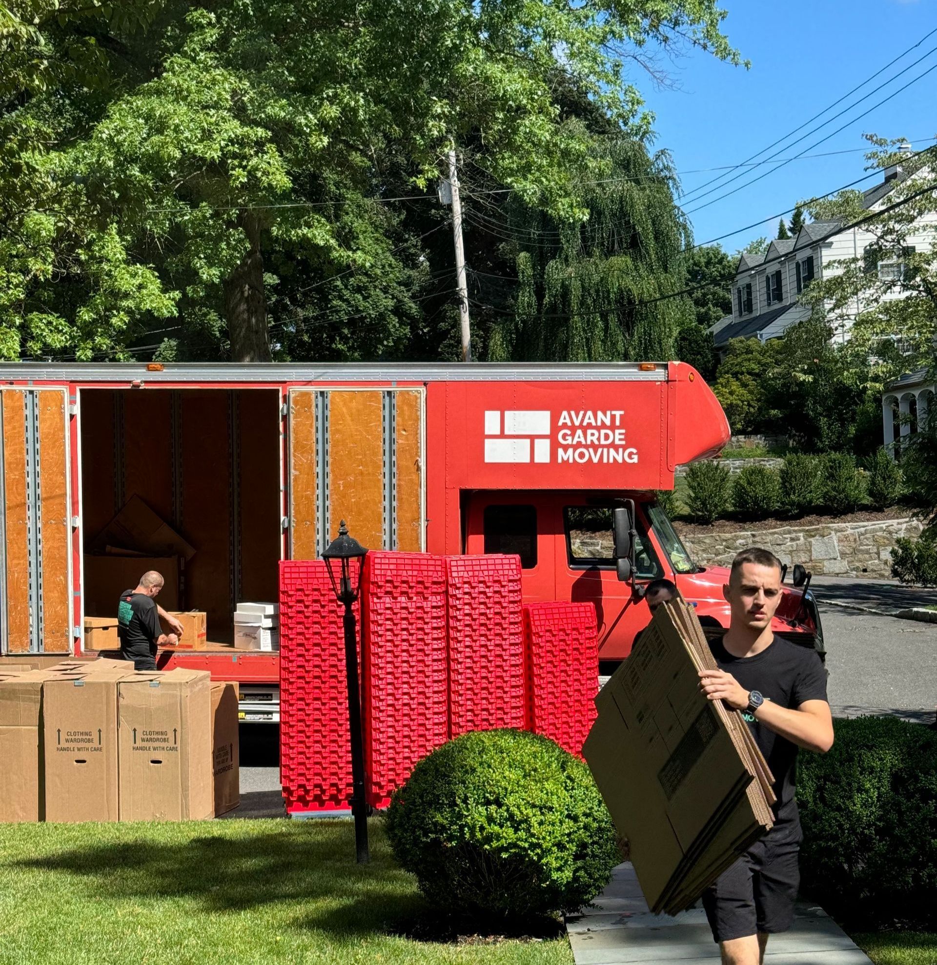 Avant-garde mover carrying out boxes from the truck to the customers house during residential move