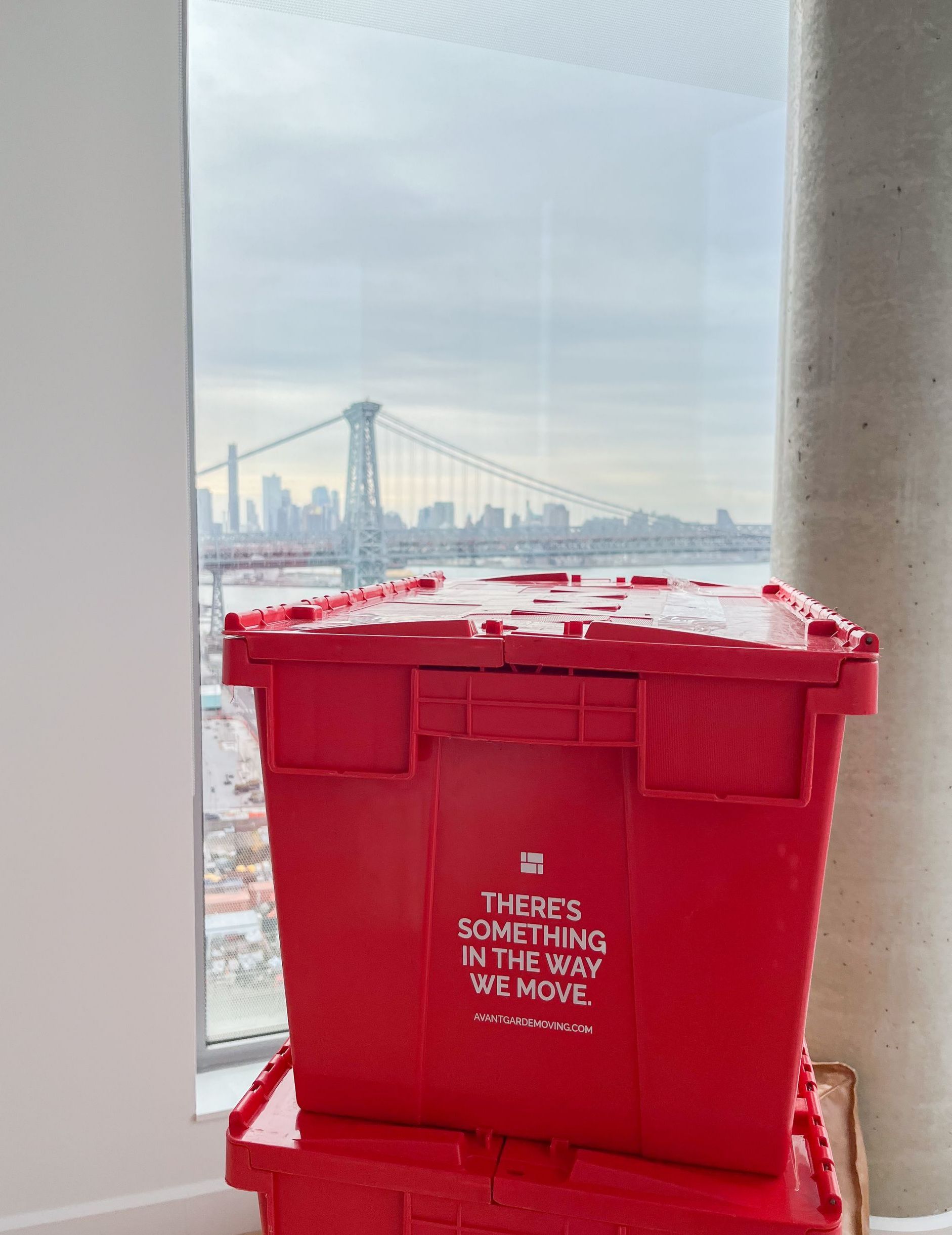 Avant-Garde Moving & Storage reusable plastic bins, stacked next to the window overlooking the NYC skyline