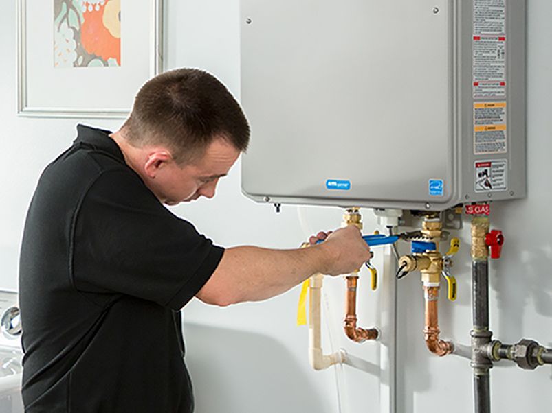 Vyras veržliarakčiu taiso vandens šildytuvą.