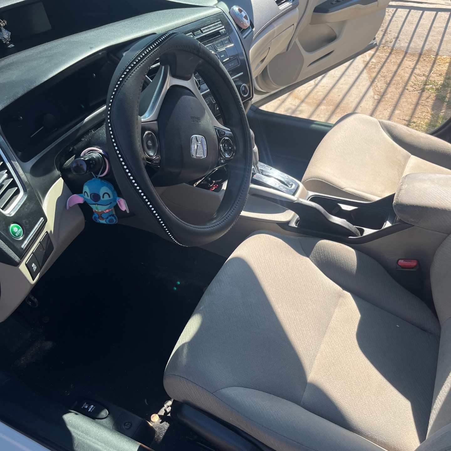 The inside of a car with a steering wheel and seats before cleaning