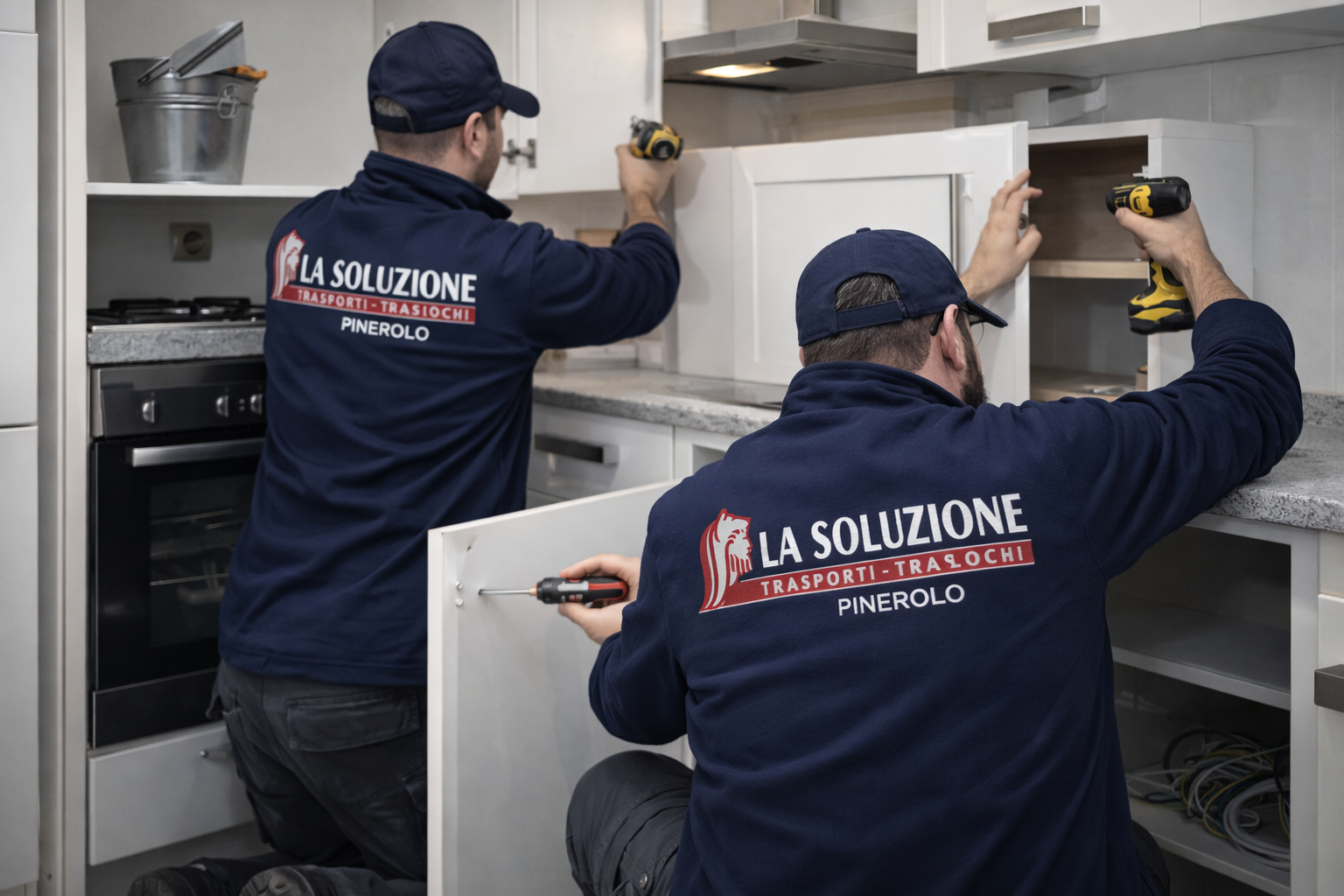 Due uomini che installano i mobili della cucina, indossando le camicie blu aziendali.