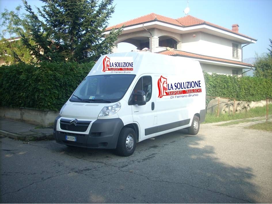 Furgone bianco con il logo aziendale parcheggiato davanti a una casa.