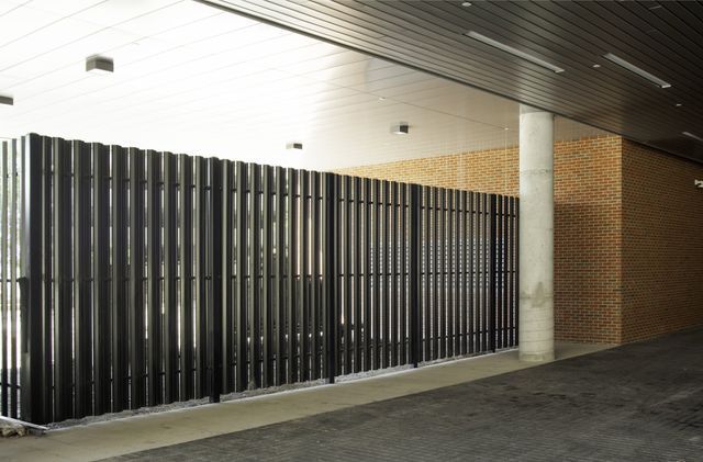 A Building With A Black Fence And A Brick Wall – Mishawaka IN - Milestone Fence