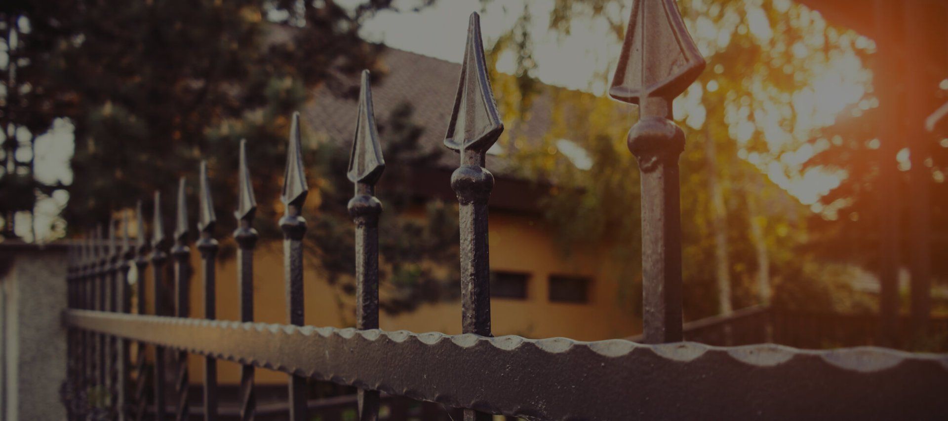 A Close Up Of A Wrought Iron Fence With A House In The Background – Mishawaka IN - Milestone Fence