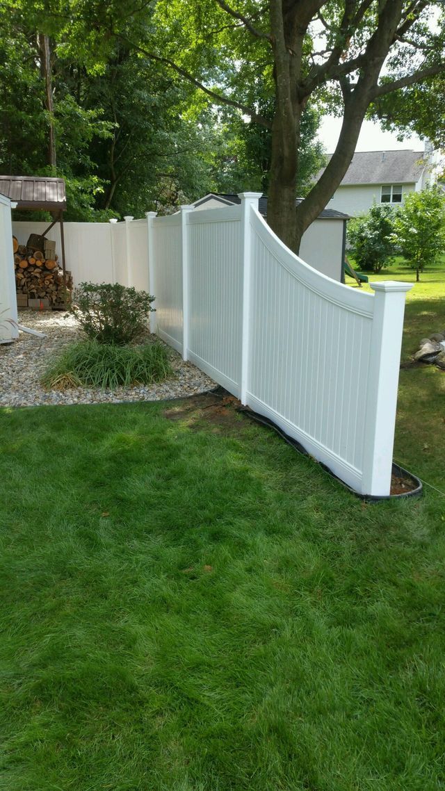 A White Fence Is In The Middle Of A Lush Green Yard – Mishawaka IN - Milestone Fence