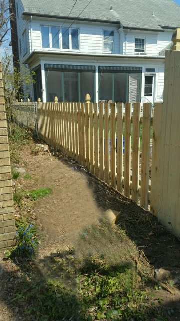 A Wooden Picket Fence Is In Front Of A White House – Mishawaka IN - Milestone Fence