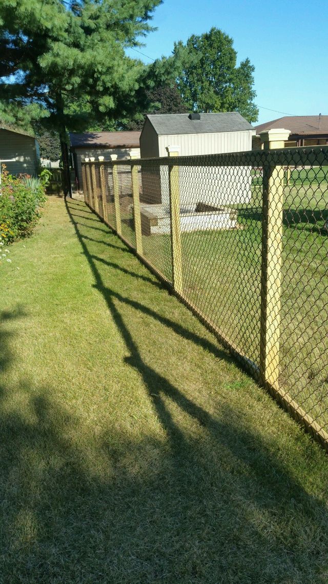 A Wooden Chain Link Fence Surrounds A Lush Green Yard – Mishawaka IN - Milestone Fence